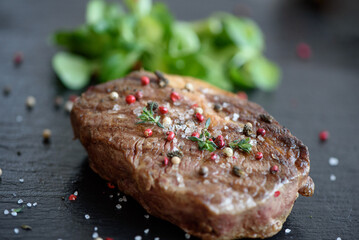 Frisch gegrilltes Rindersteak mit grünem Gemüse im Hintergrund