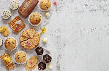 Easter festive family dessert table with various of waffles, muffins and sweets. Flat layot