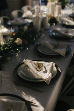 Light falls on dinner table and napkins during small wedding and elopement ceremony.