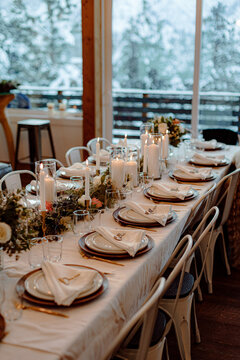 dinner plates on white tablecloth with centerpiece and candles during evening wedding elopement celebration.