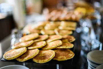 Many pancakes ready to be picked up on a buffet in a luxury hotel