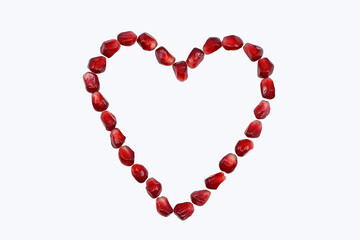 Heart made of pomegranate seeds, isolated on white background, copy space for text