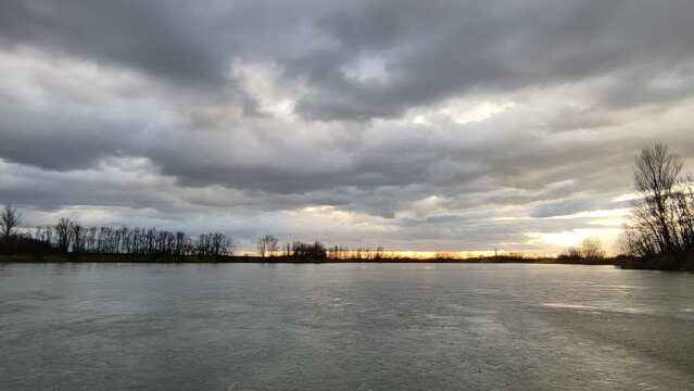 Afternoon clouds above the frozen lake. 4K time lapse.