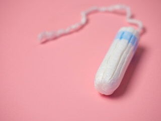 female tampon on a pink background. Hygienic white tampon for women. Cotton swab. Menstruation, Tampons on a pink background.