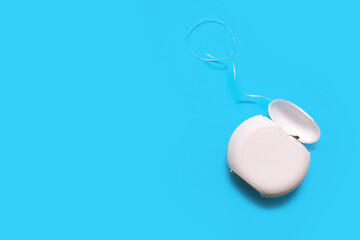 Dental floss for cleaning teeth on a blue background. The concept of oral care and caries...