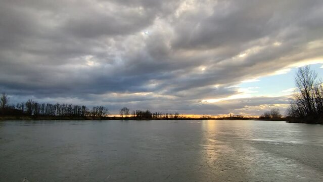 Afternoon clouds above the frozen lake. 4K time lapse.