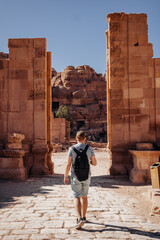 Tourist with a backpack visiting the sights of the ancient fabulous city of Petra in Jordan. Colorful photos. Vacation, vacation and travel concept
