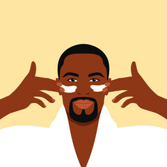 Bearded african man in a white bathrobe applies cream to his face. Daily skin care routine 