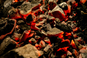 Background of burning and glowing embers. smoldering embers of fire. flicker of burning coals at night. Selective focus