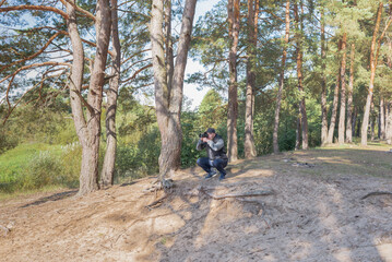 Obraz premium Man nature photographer taking pictures in the forest.