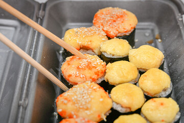 Bamboo sticks for sushi in a set. Various rolls, maki, nigiri in assortment in plastic packaging.