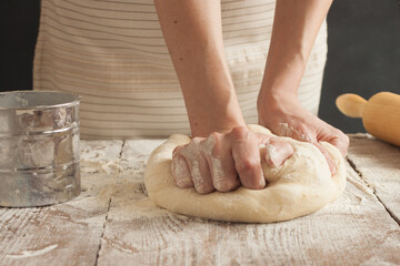 Obraz na płótnie Canvas A woman kneads the dough