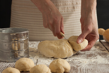 A woman cuts the dough