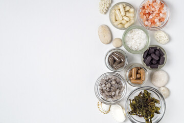 Dietary supplements in capsules, white, gray, pink crystals of salt, algae, in glass jars