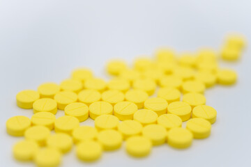 Medical and Healthcare Concept. Closeup of pile of yellow pills on white background.