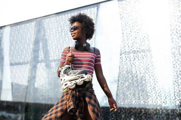 Fototapeta na wymiar Beautiful African woman with roller skates. Urban sexy girl enjoy outdoors...