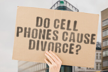 The question " Do cell phones cause divorce? " on a banner in men's hand with blurred background. Marriage. Caution. Dispute. Doubt. Upset. Dating. Lover. Jealous. Couch. Fight. Anxiety. Cell. Girl