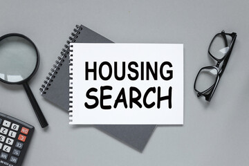 HOUSING SEARCH text on notepad on gray background with pencil