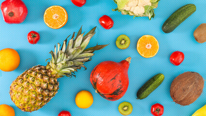 Creative pattern with various vibrant fresg fruits and vegetables on cyan background. Flat lay compostition.