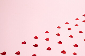 Red confetti hearts pattern on rose background. Valentine's day or wedding day card concept