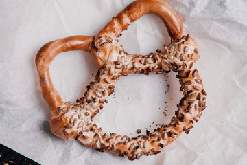 Fresh prepared homemade soft pretzels. Different types of baked bagels with seeds on a black background.