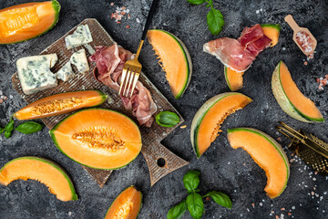 Cantaloupe melon with ham prosciutto jamon. Traditional Spanish and Italian appetizer. banner, menu, recipe top view