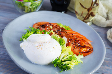 Fresh salad with burrata, lettuce and tomatoes. Delicious Italian cheese made from mozzarella and cream