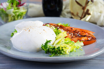 Fresh salad with burrata, lettuce and tomatoes. Delicious Italian cheese made from mozzarella and cream
