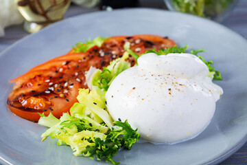 Fresh salad with burrata, lettuce and tomatoes. Delicious Italian cheese made from mozzarella and cream