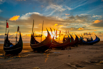 View of traditional fishing boats along the shoreline at sunset on the beach on St. Martin's Island, Teknaf, Chittagong, Bangladesh.