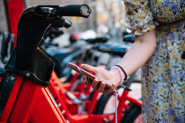 Woman using smartphone for renting bicycle