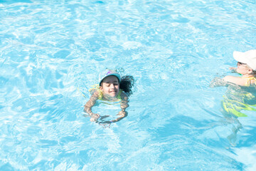Happy family. Mom teaches her daughter to swim in the pool. Top view.