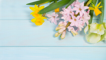 Different delicate spring flowers on a blue wooden background. Image with selective focus