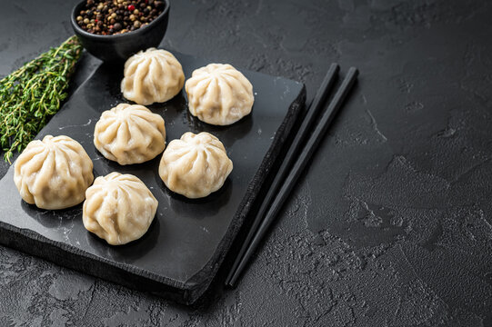 Chinese baozi dumplings on a marble board. Black background. Top view. Copy space