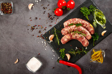 Raw barbecue sausages with spices and vegetables. Top view. Free space for your text.