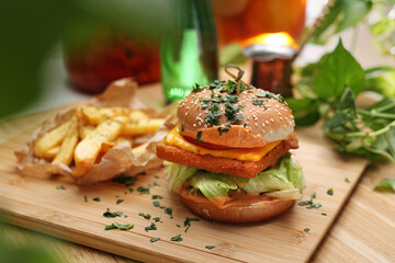 Vegan cheeseburger on a wooden cutting board, selective focus, close up. Plant-based meal, vege lunch, horizontal view.