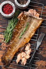 Salmon Hot smoked fish on a grill with herbs. Dark Wooden background. Top view