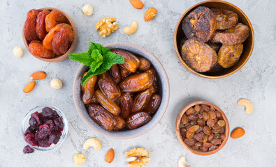 Top view of the table on which there are different bowls with dried fruits
