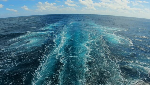 Wake of vessel. Back view. Ocean water. Deep blue. Wide trace