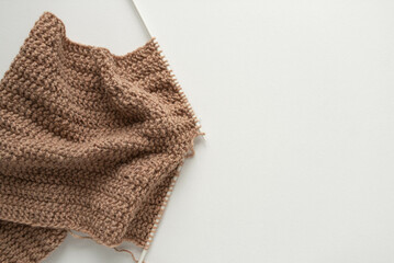 Knitted beige scarf top view. Close-up knitting.