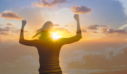 Strong motivated you Woman flexing her arms up to the sunrise. 