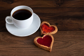 A cup of coffee on a wooden background with heart-shaped cookies. Valentine's Day. selective focus