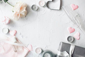 The theme is Valentine's Day. Packed gift, rose and pink hearts with other romantic decoration located around the perimeter of the white background. Copy space. View from the top point. 