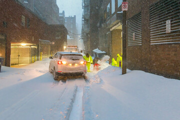 Car in Boston ally being shoveled out to clear the way for snow plow