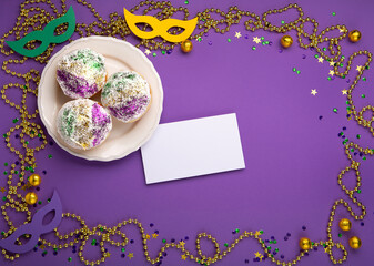 Mardi Gras King Cake sufganiyot donuts, masquerade festival carnival masks, gold beads and golden,...