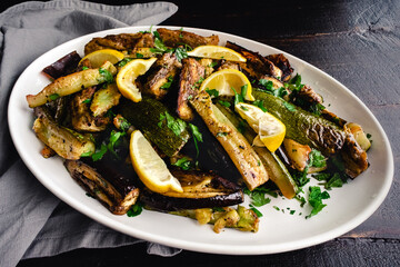 Roasted Aubergine and Courgette with Sumac and Herbs: Roasted eggplant and zucchini served on a white platter