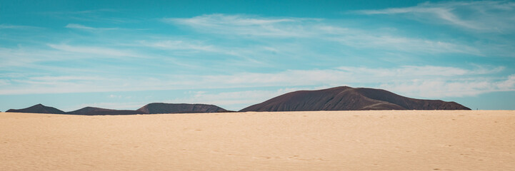 Fototapeta na wymiar Landschaft mit Wüste und Vulkan Panoramaformat