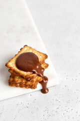 Chocolate paste pouring down on Crackers or cookies. Food porn