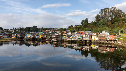 Ein Panorama von Castro auf Chiloé, mit den bunten, hölzernen Stelzenhäuser, welche sich im seichten Wasser spiegeln