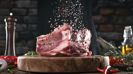  Close-up of falling salt and pepper on tasty beef steak in kitchen, freeze motion. © Lukas Gojda